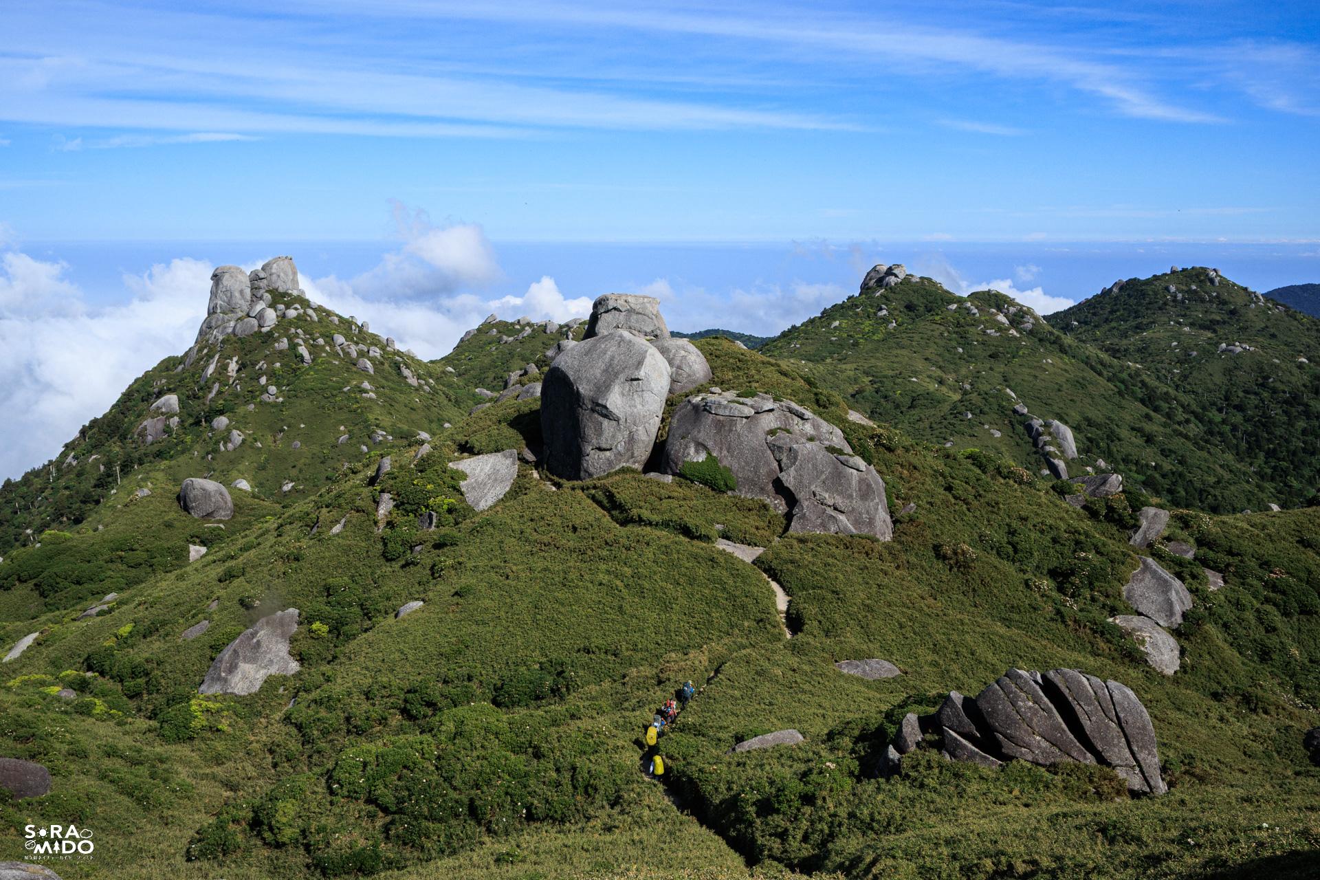 栗生岳や翁岳を望みながら、屋久島トレイルを下山するガイド仲間の列